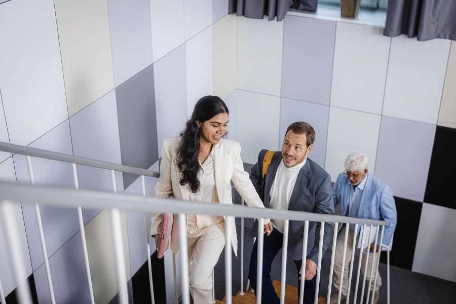 Three people in stairs going up.