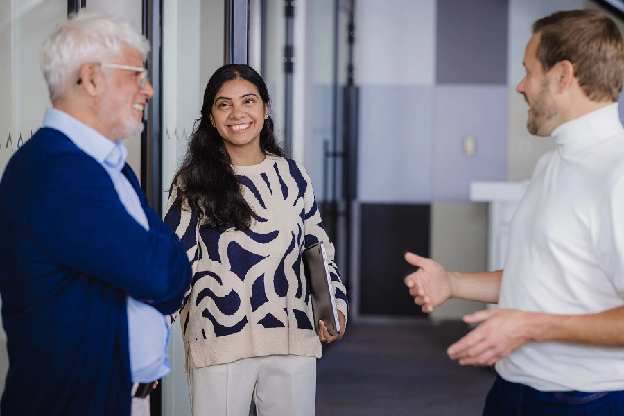 Three people talking and smiling at the office
