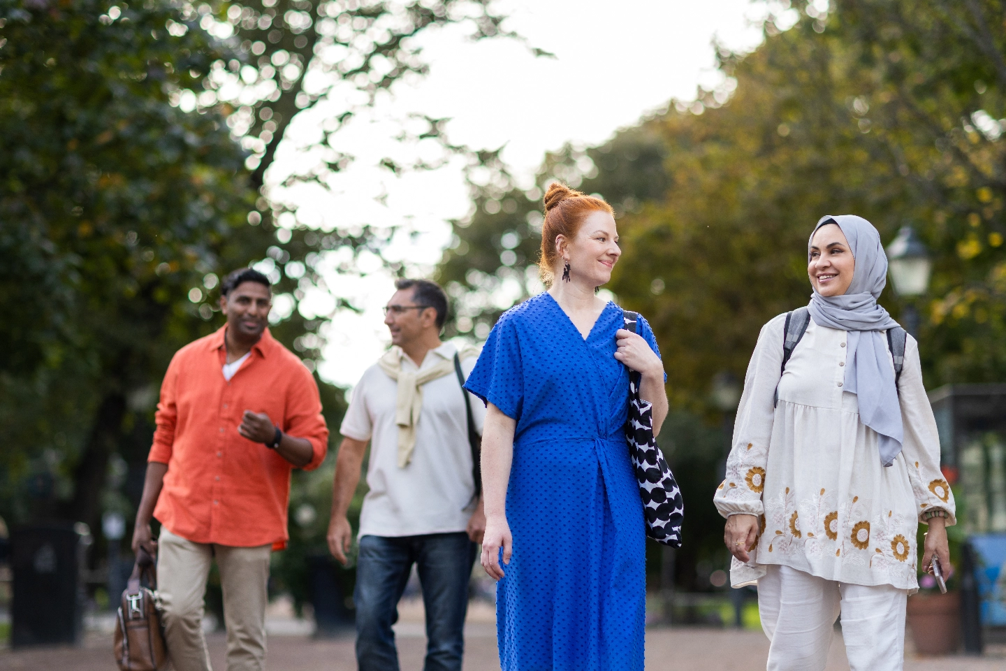 A group of people is walking and talking on the street