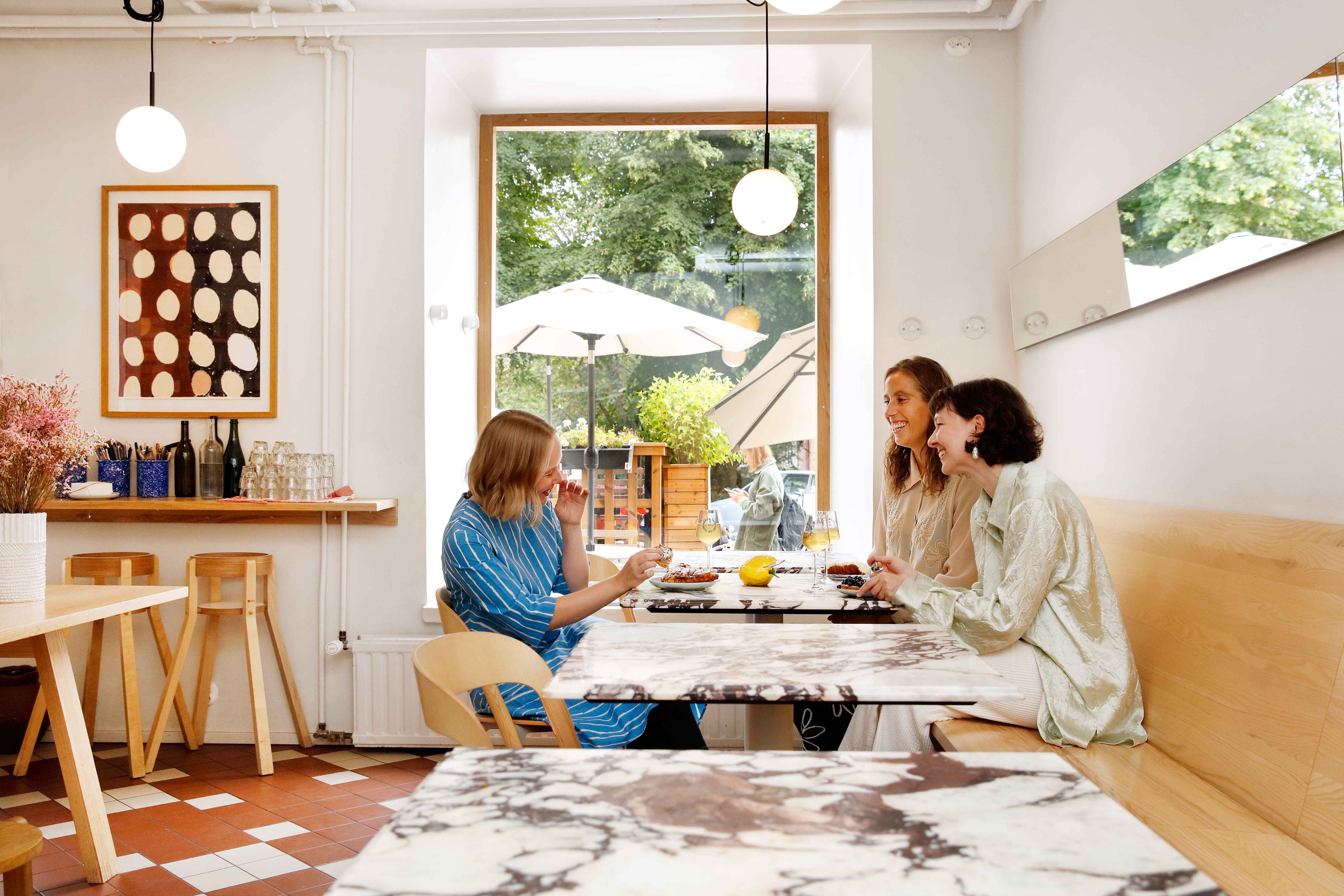 Women sitting and laughing in a cafe in Helsinki.
