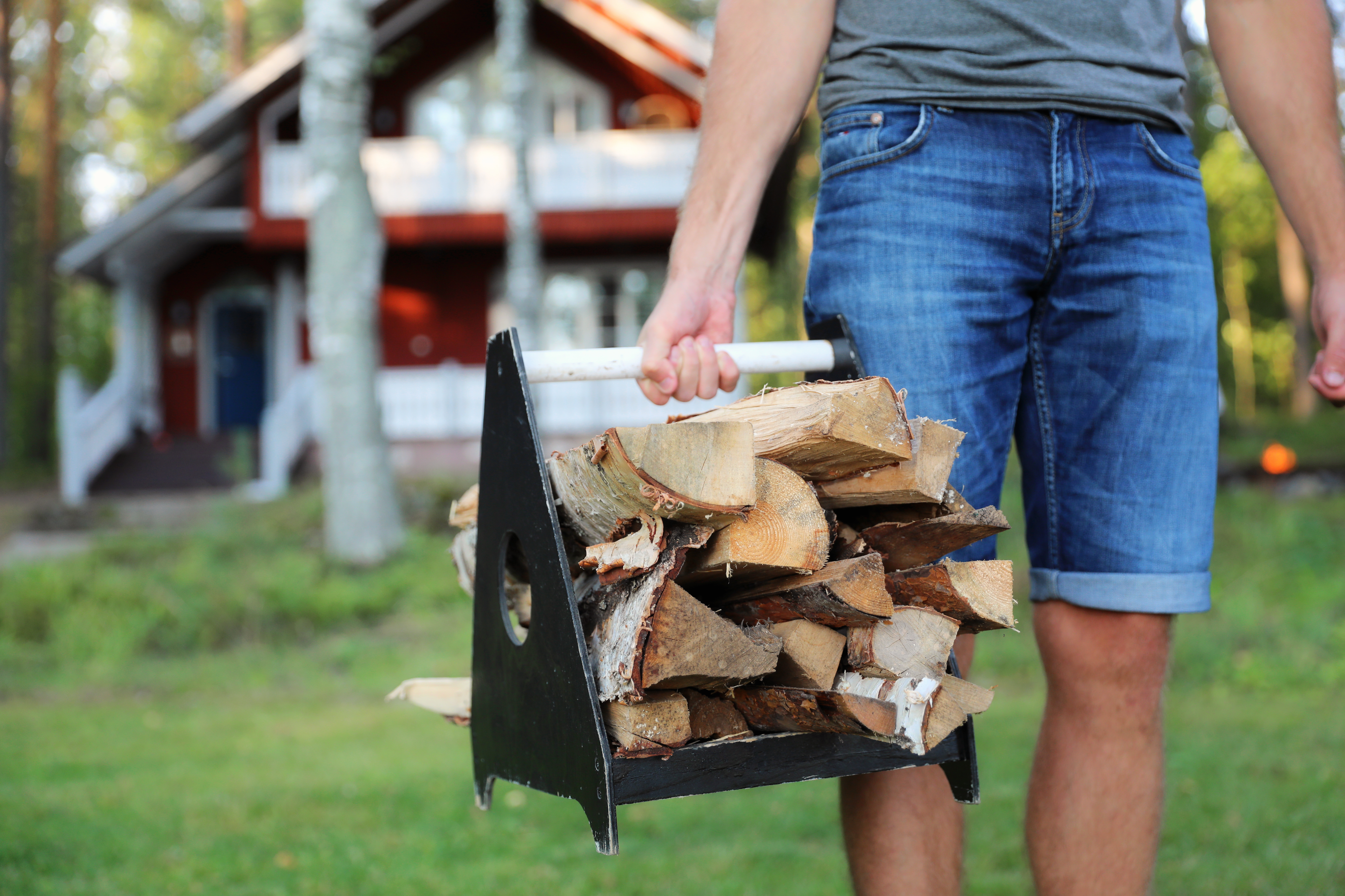 a man carrying firewood to the sauna