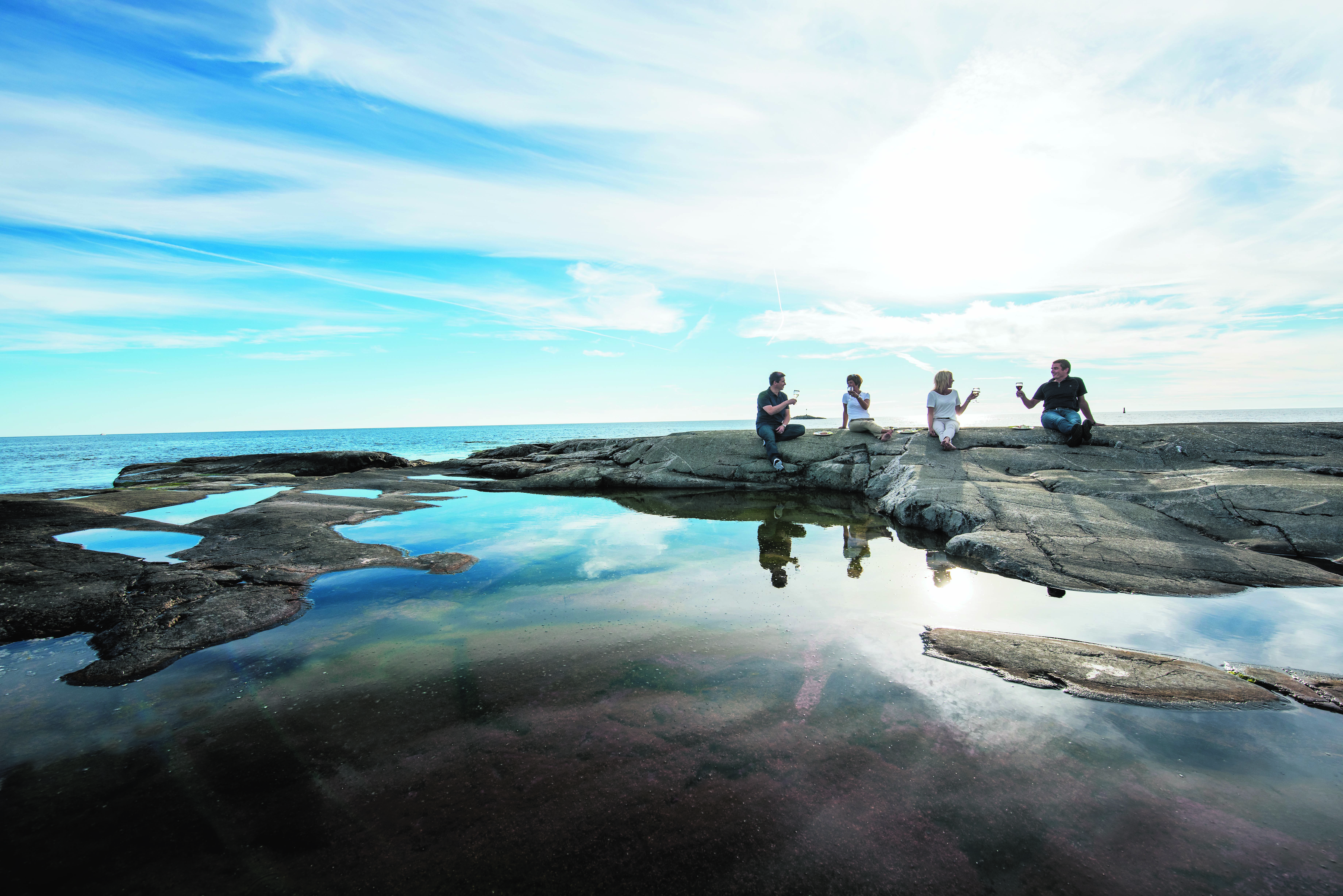 People enjoying wine on the rock at the Åland archipelago