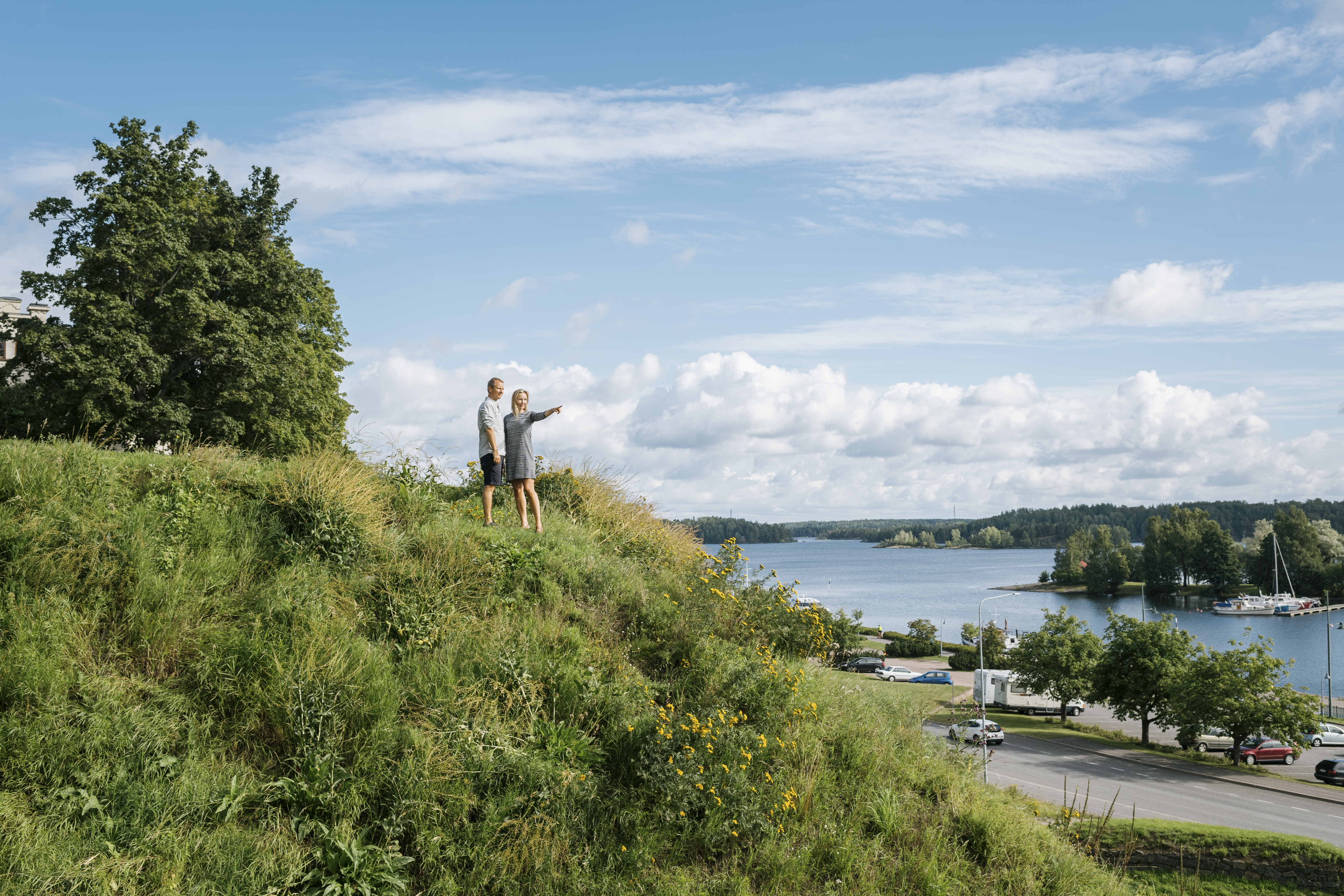 People standing on a hill by the lake