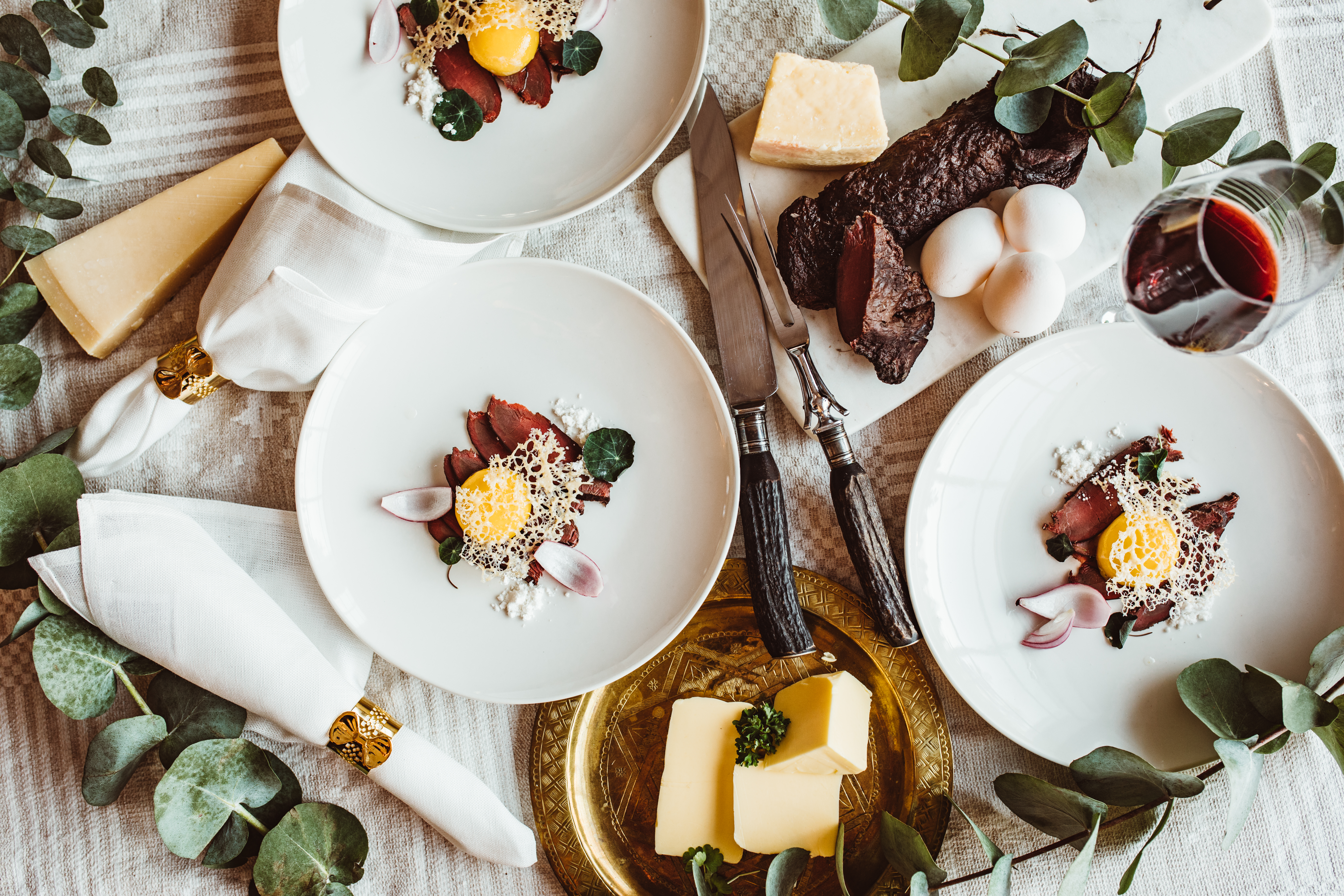 A picture of a La Carte dish of smoke reindeer with red onion, egg yolk and parmesan