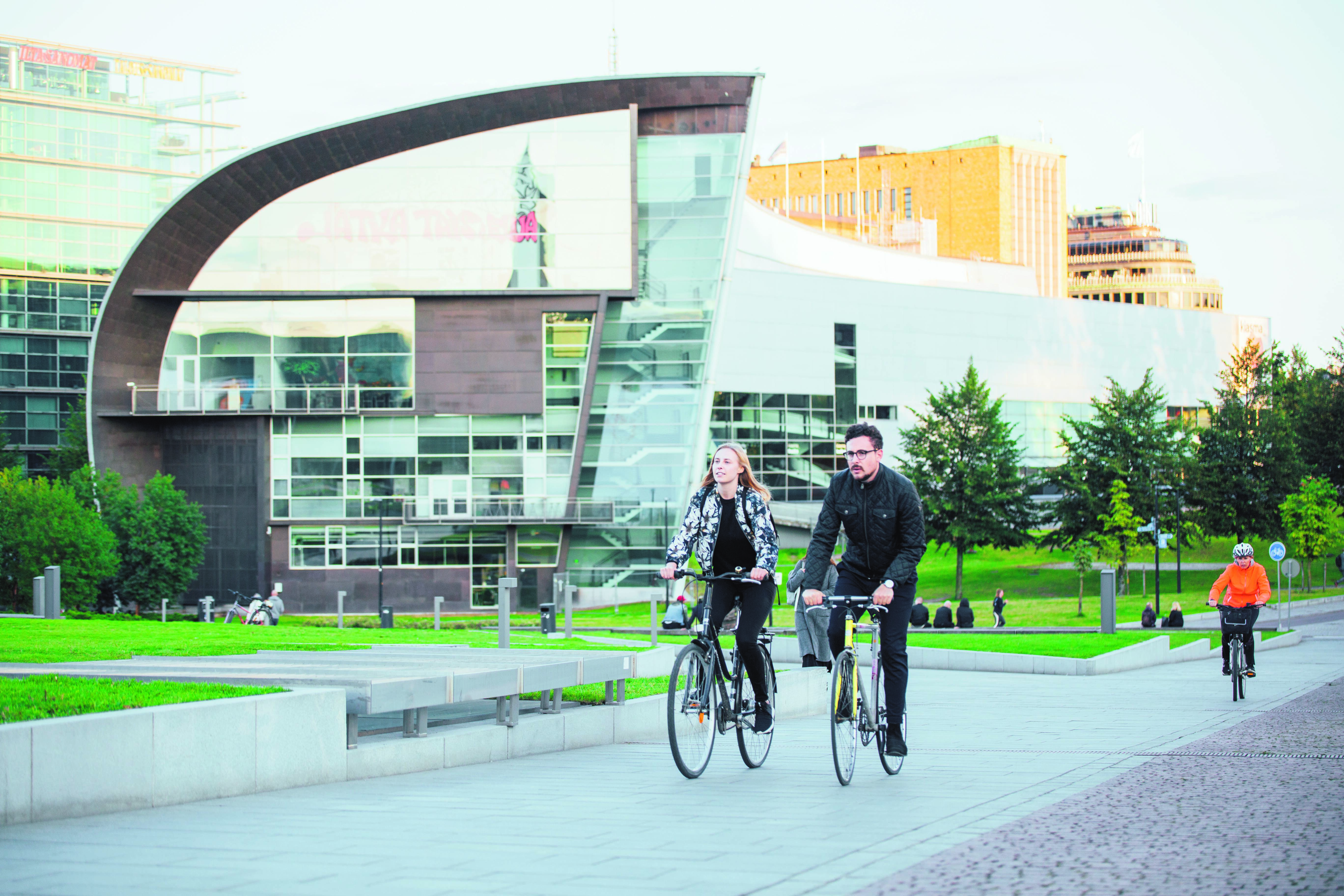 Two people cycling in an urban surrounding