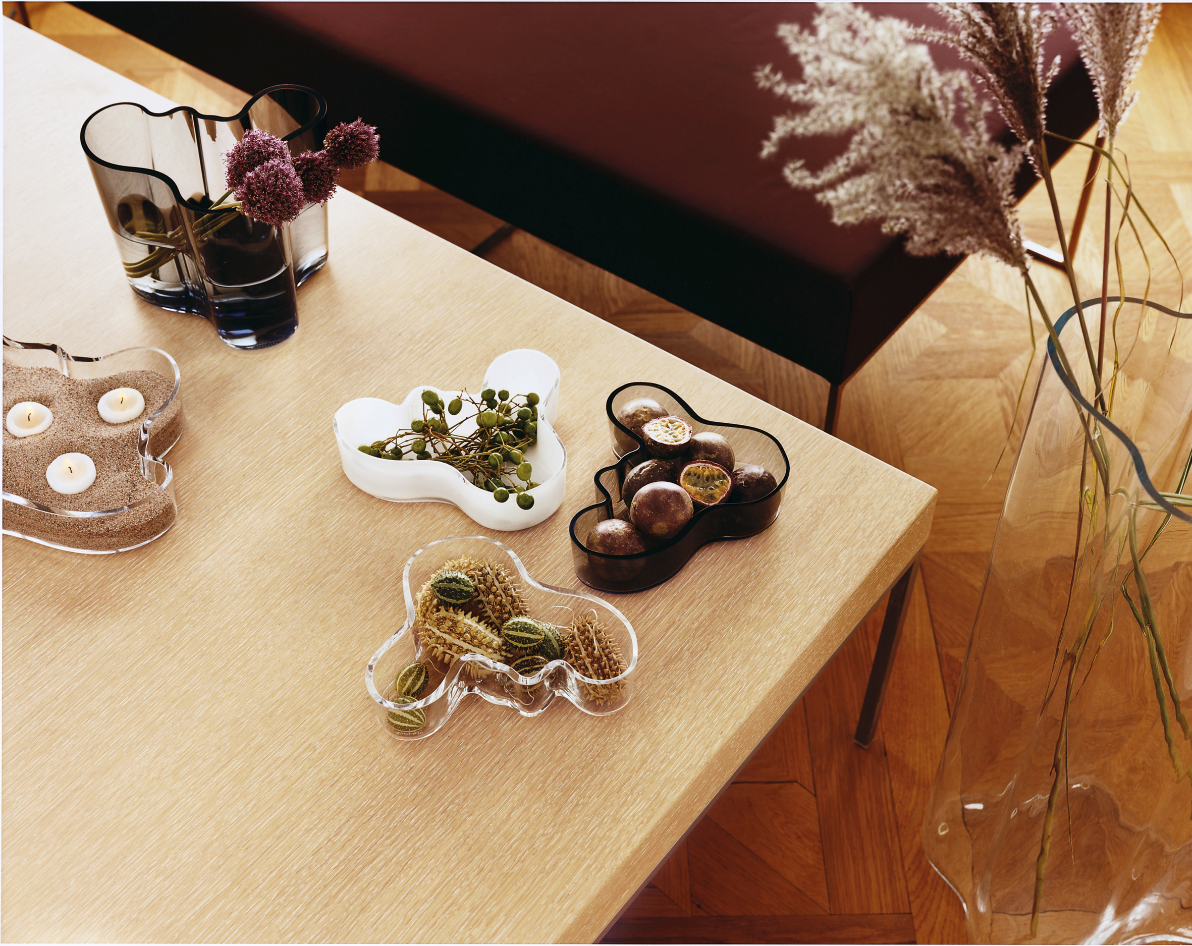 Differently coloured Aalto Vases (also known as the Savoy Vases), pieces of glassware on a table in a Iittala flagship store