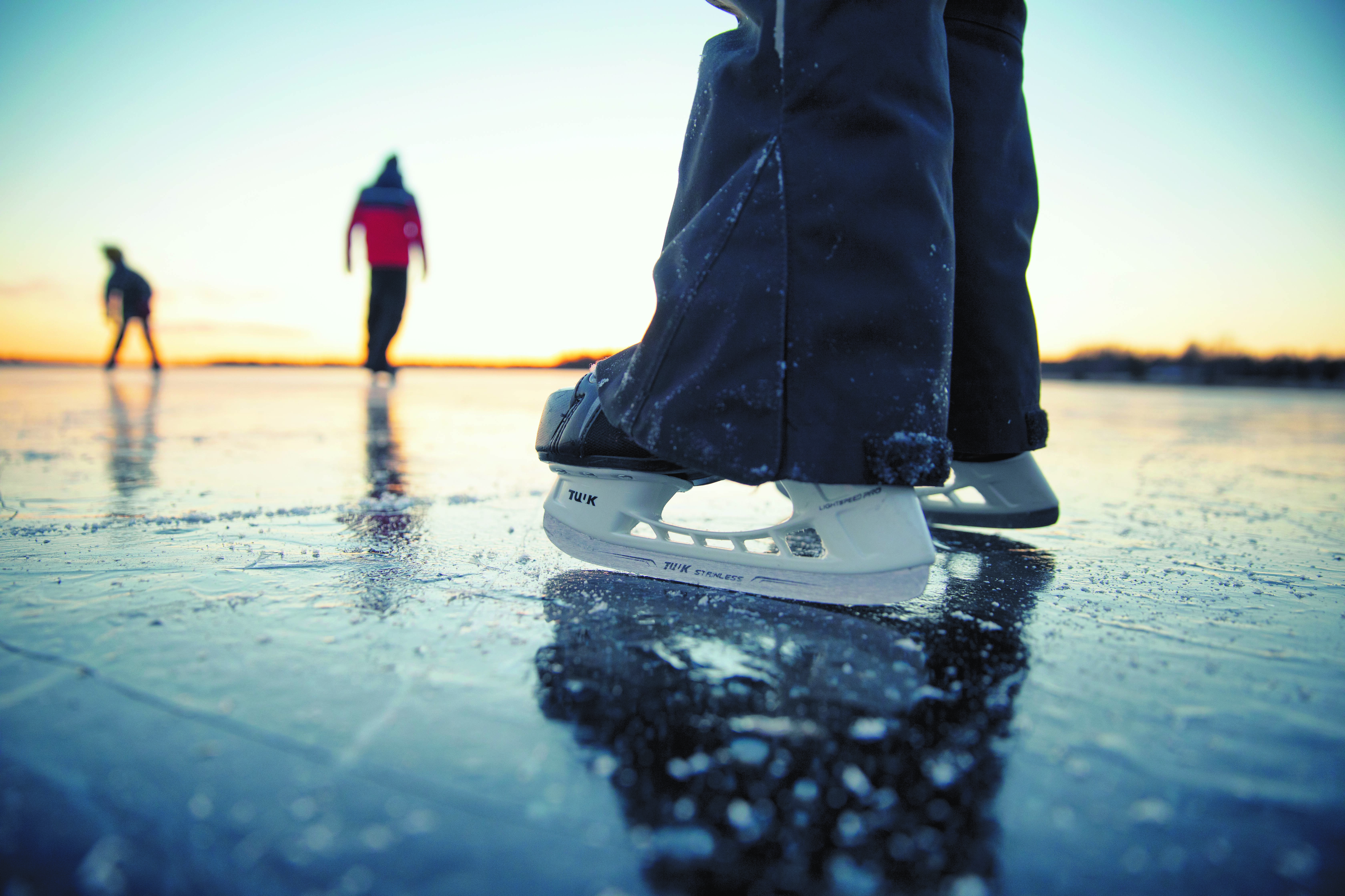 close up of a skater's skates on the ice of a lake