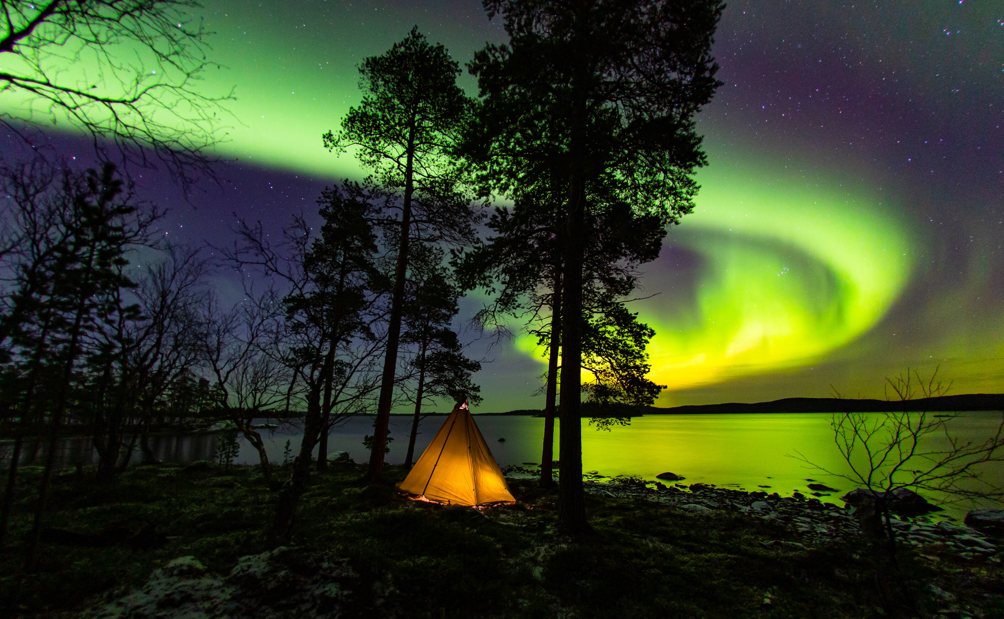 Camping by the lake under the Northern Lights